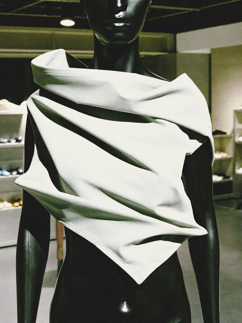 Studio illustrato di un top drappeggiato a pannelli dalla silhouette originale.